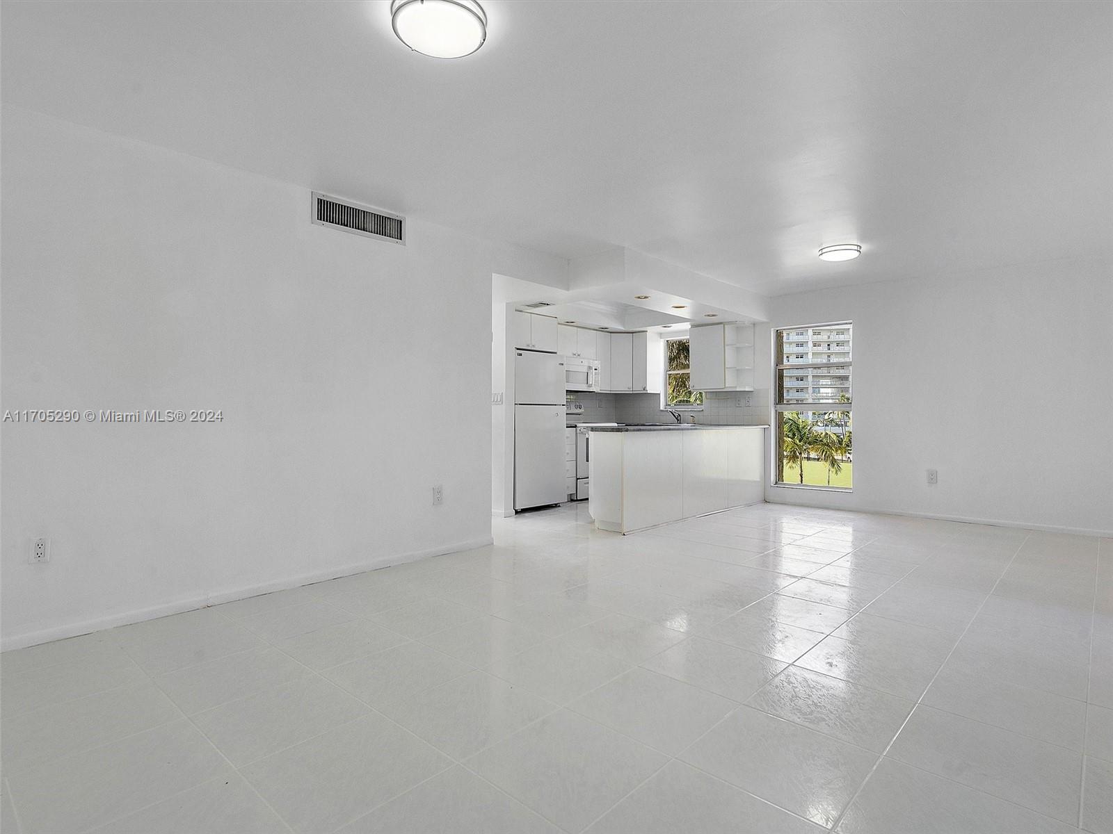 a view of a kitchen with a sink and dishwasher a refrigerator with wooden floor