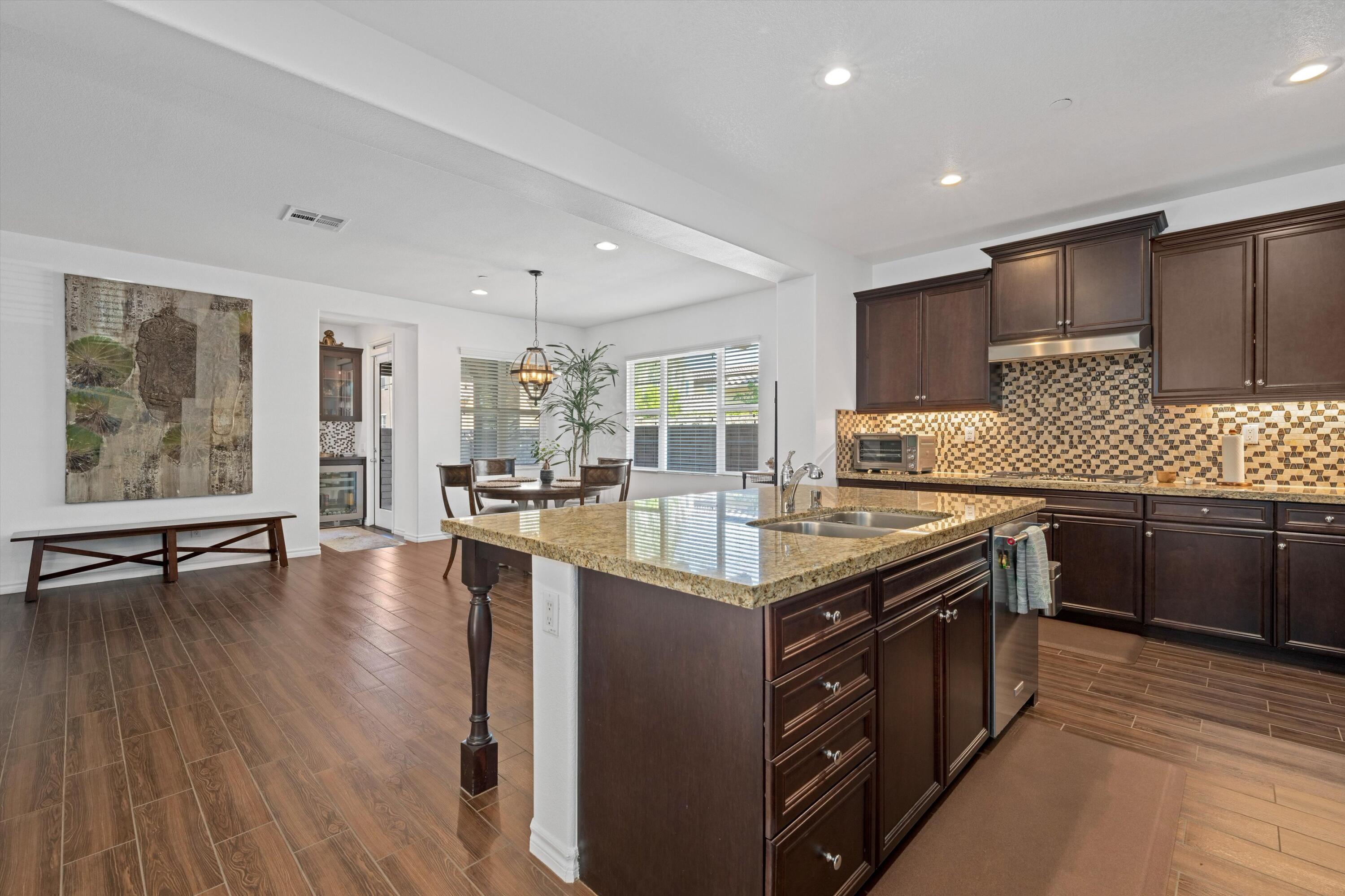 a kitchen with stainless steel appliances granite countertop a stove and a wooden floors