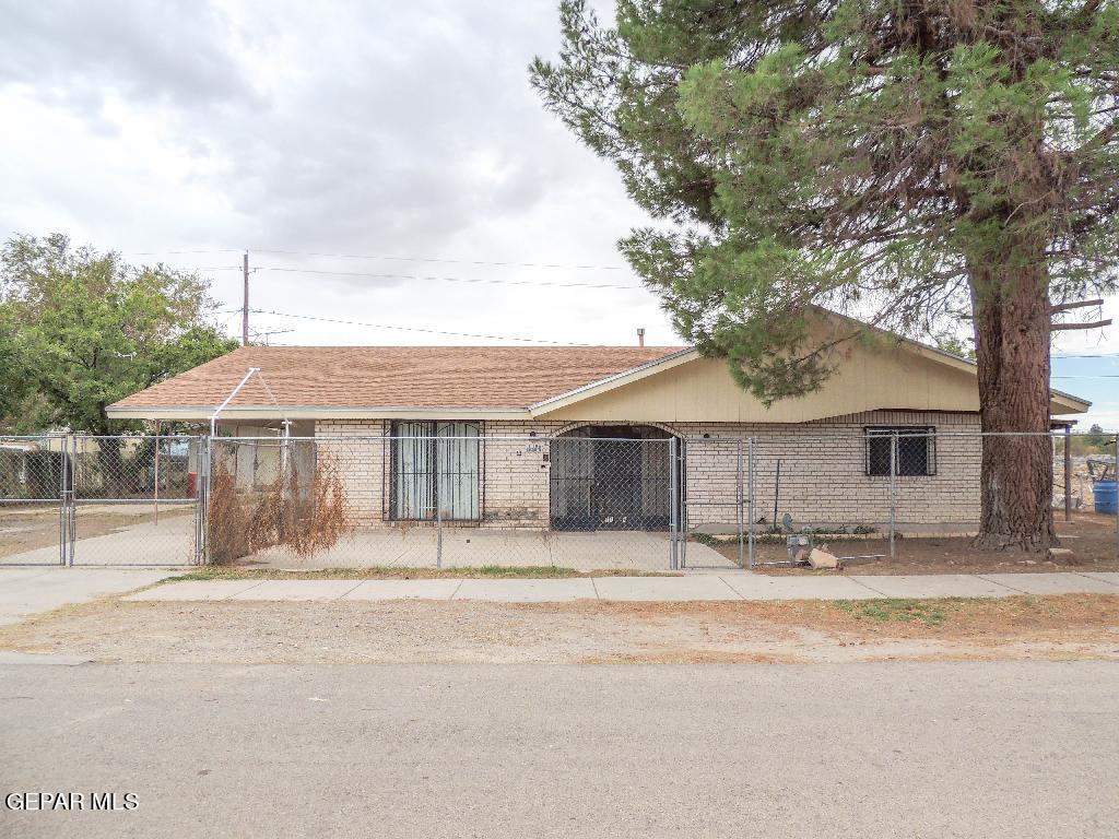 a front view of a house with a tree