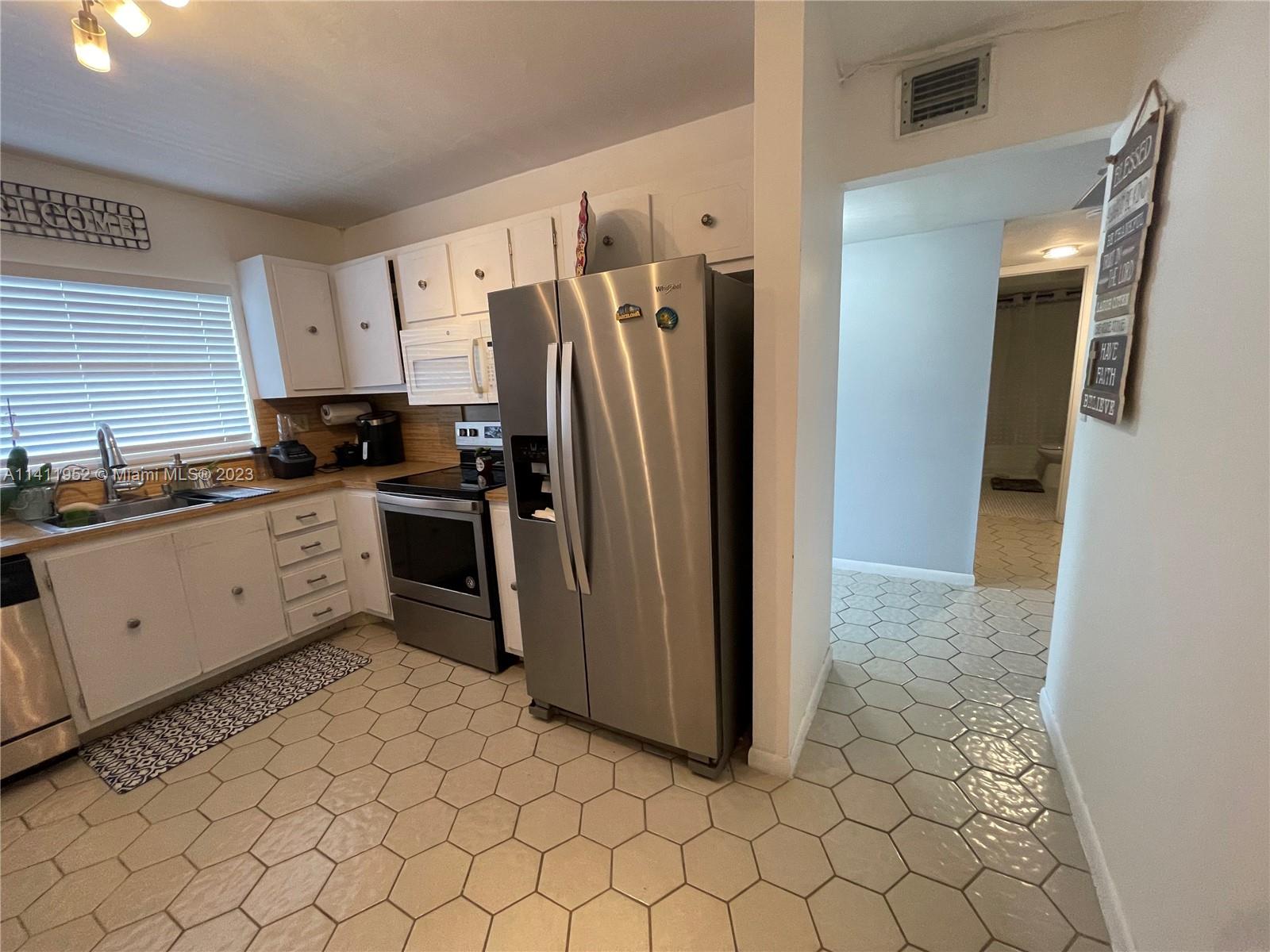 a kitchen with stainless steel appliances a refrigerator sink and microwave