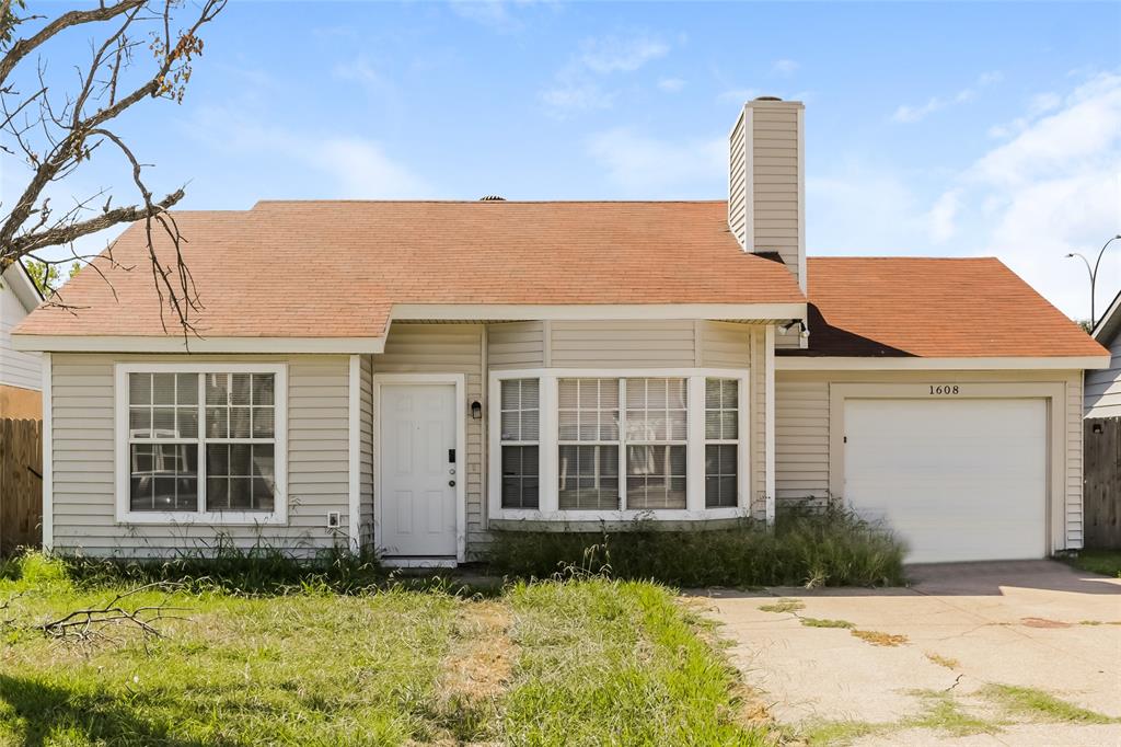 a front view of a house with a garden and yard