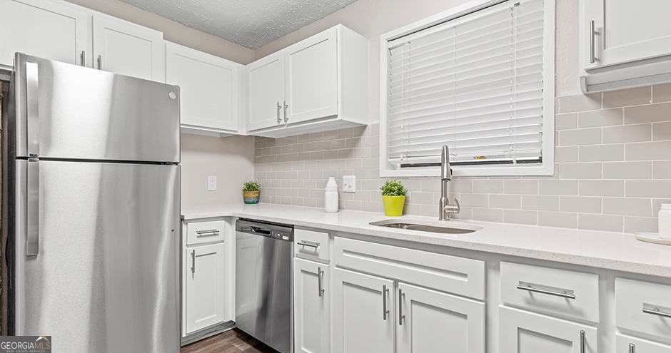 a white refrigerator freezer sitting in a kitchen with white cabinets