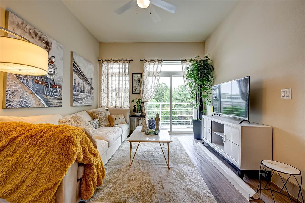 a living room with a bed furniture and a flat tv screen next to a window