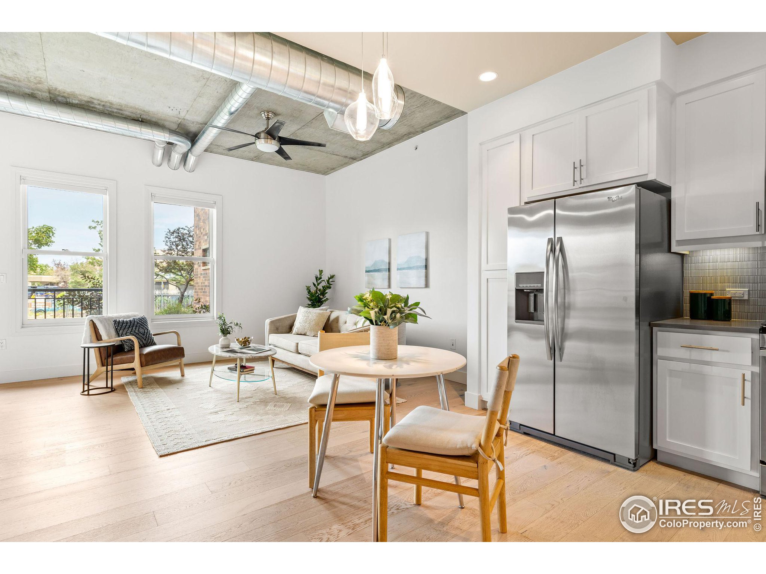 a living room with stainless steel appliances kitchen island granite countertop furniture and a refrigerator