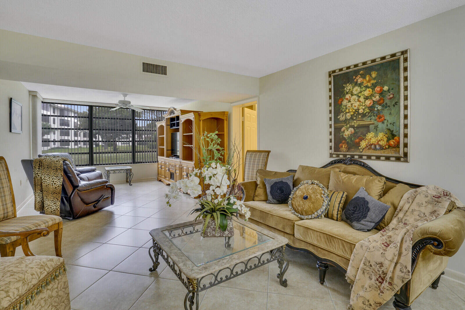 a living room with furniture and floor to ceiling windows