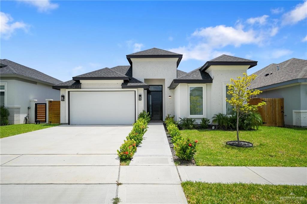 View of front of property featuring a garage and a front yard