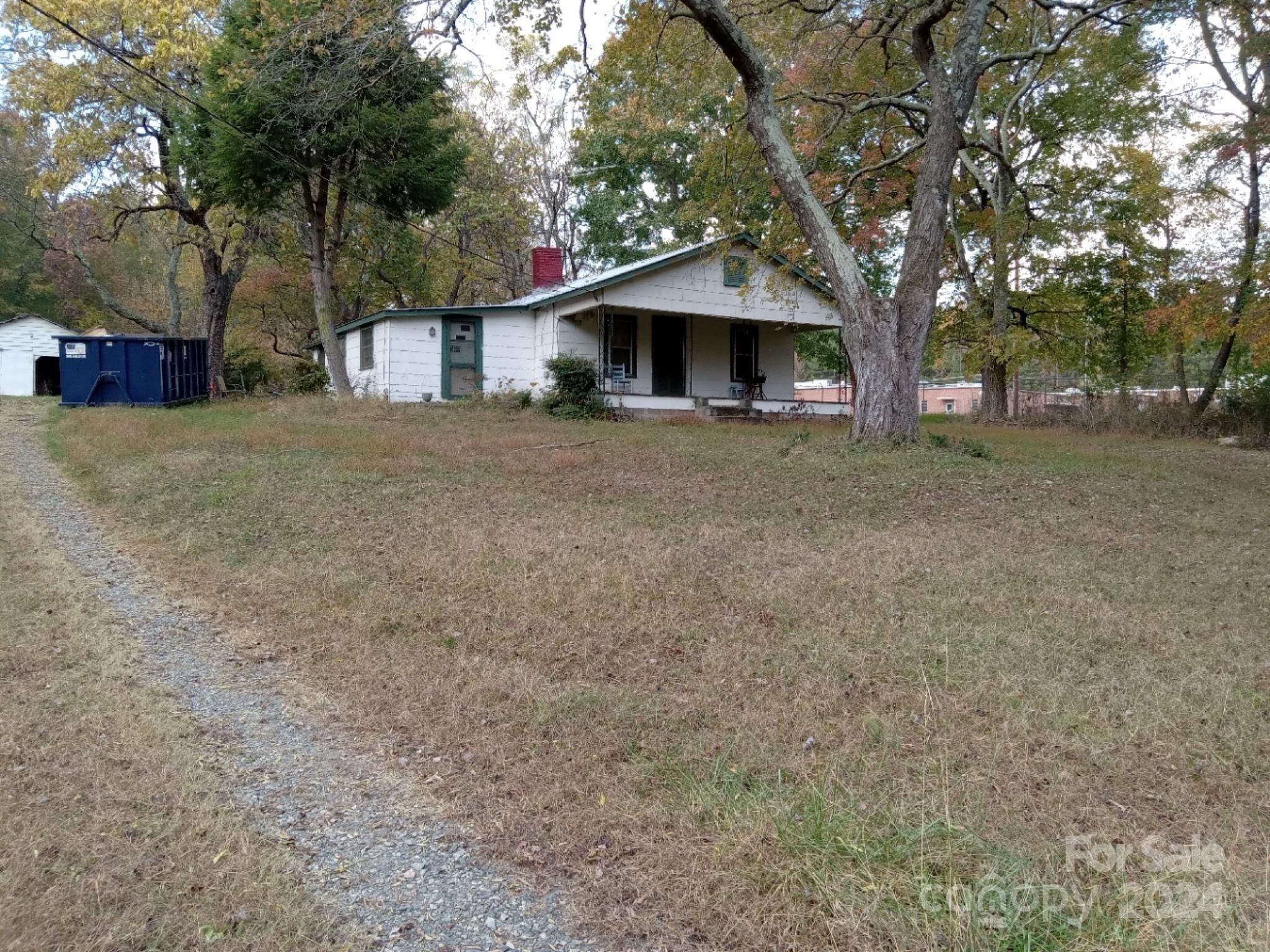 a front view of a house with a tree and a yard