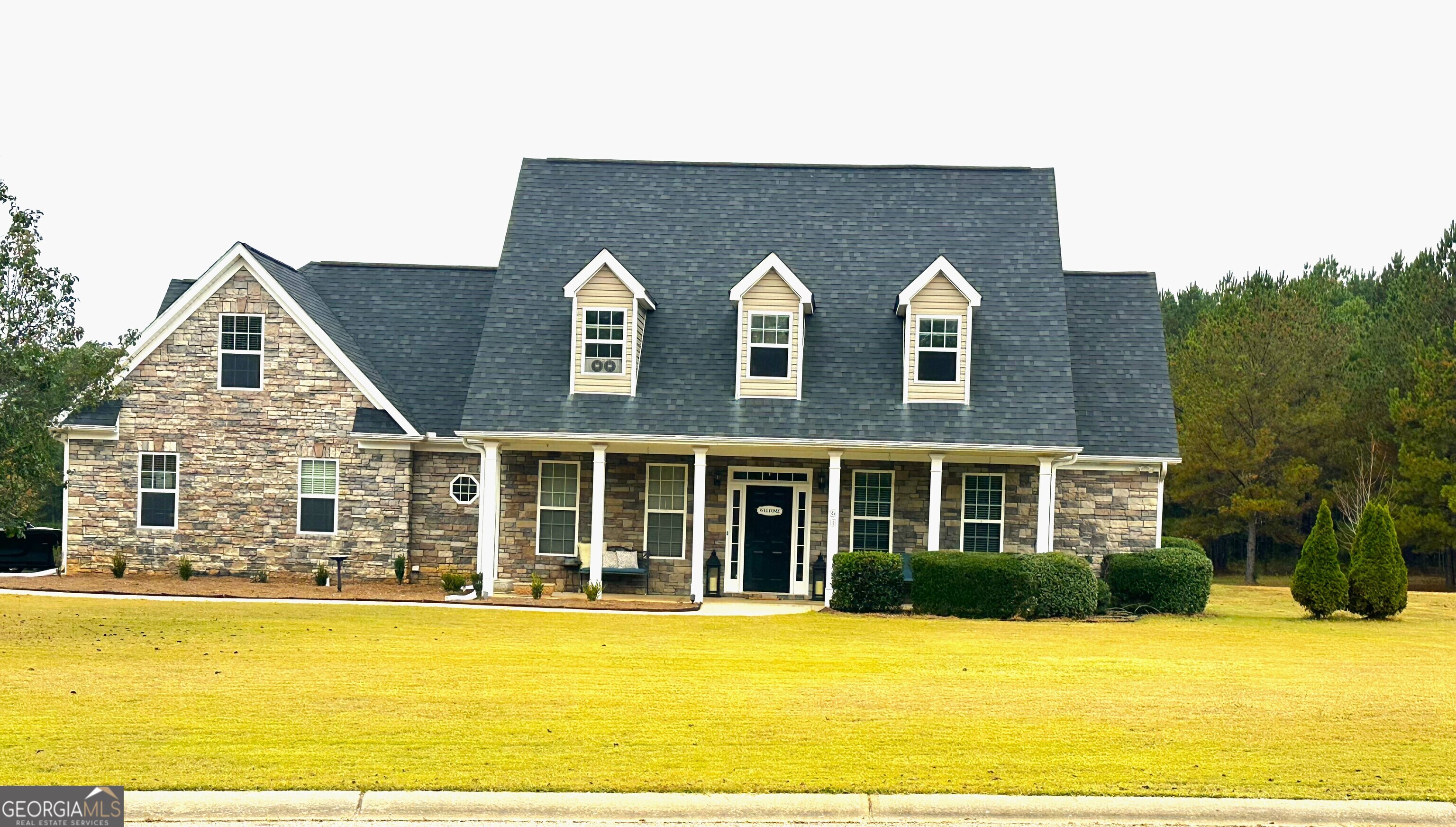 a front view of a house with a garden