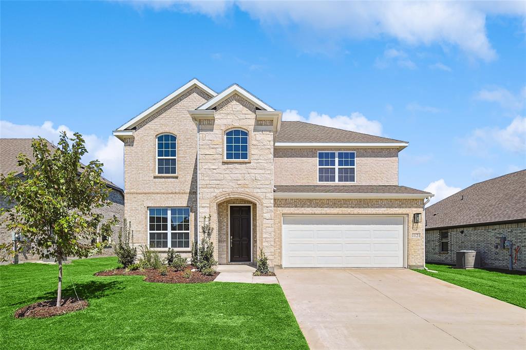 a front view of a house with a yard and garage