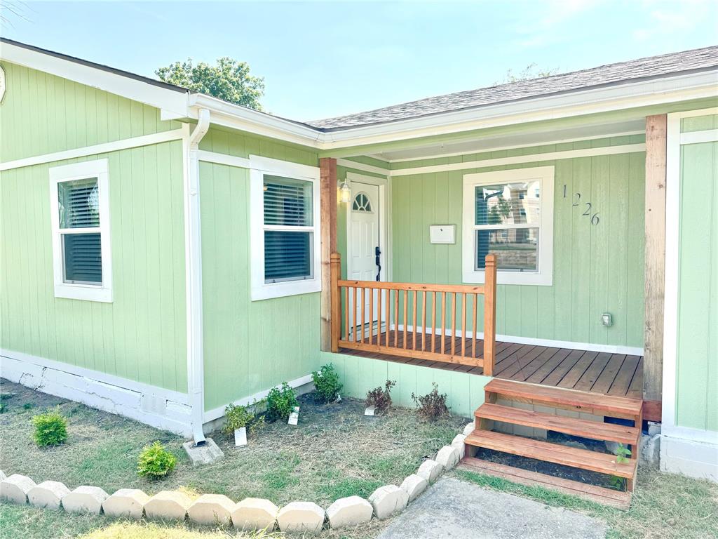 a view of a house with a small yard and wooden fence