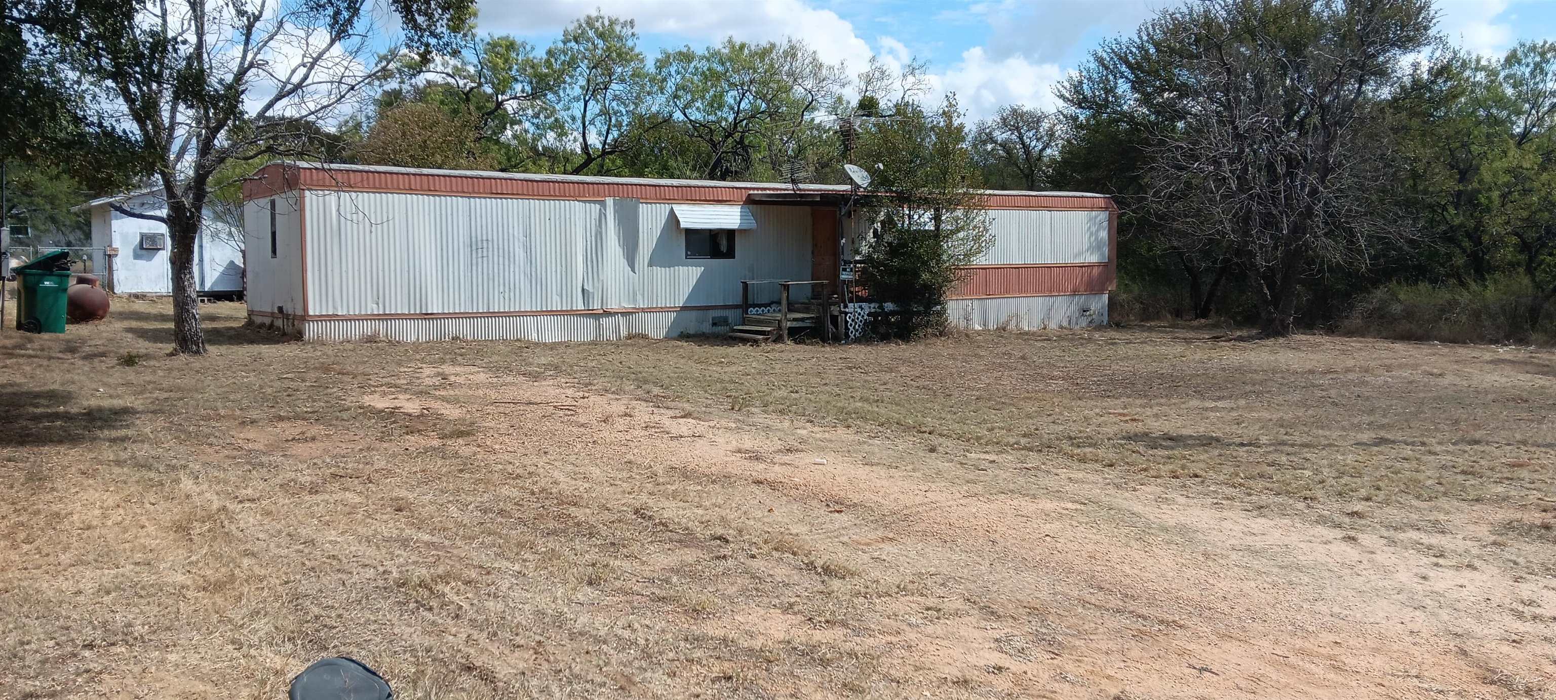 a view of a house with backyard and trees