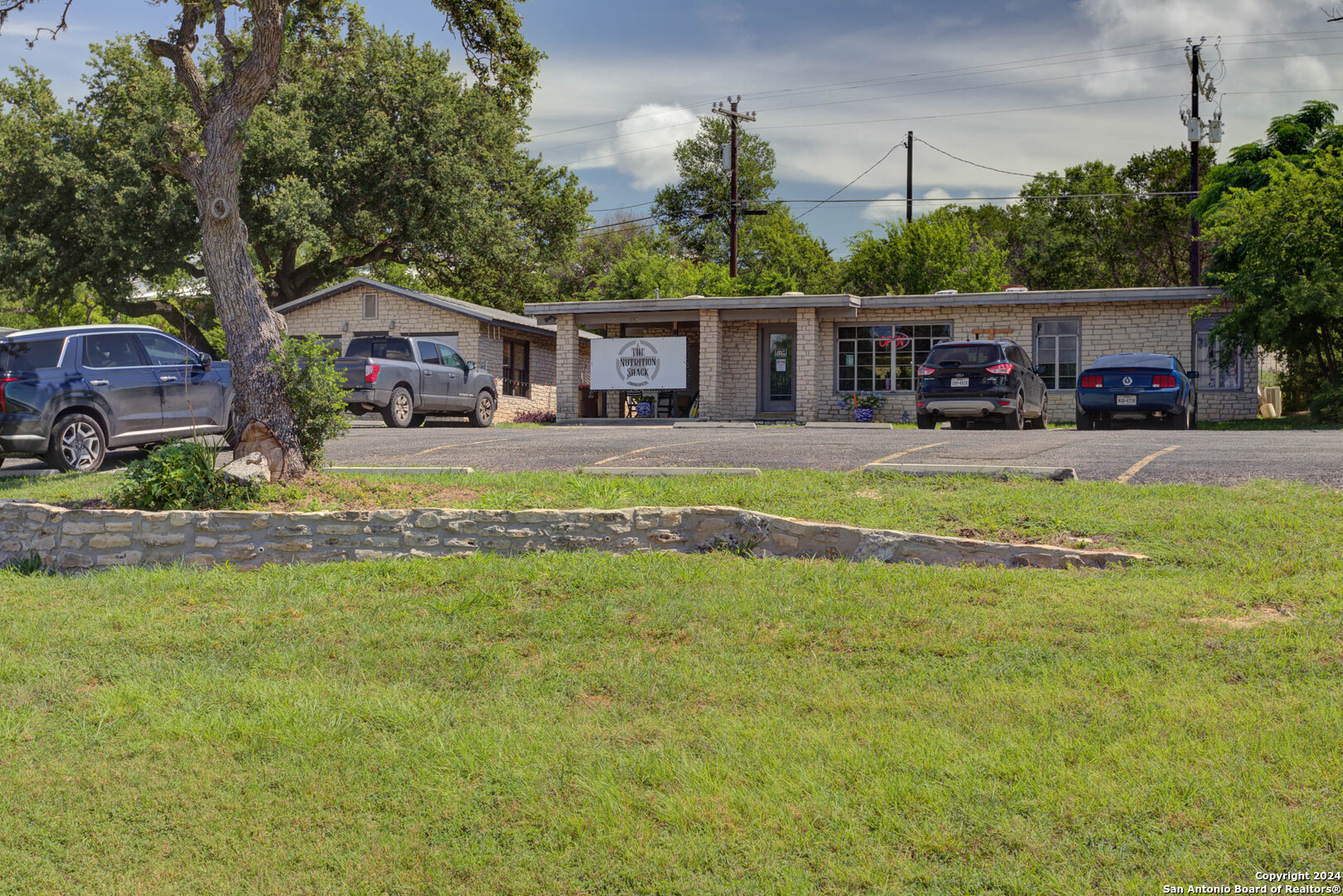 a front view of a house with a garden and trees