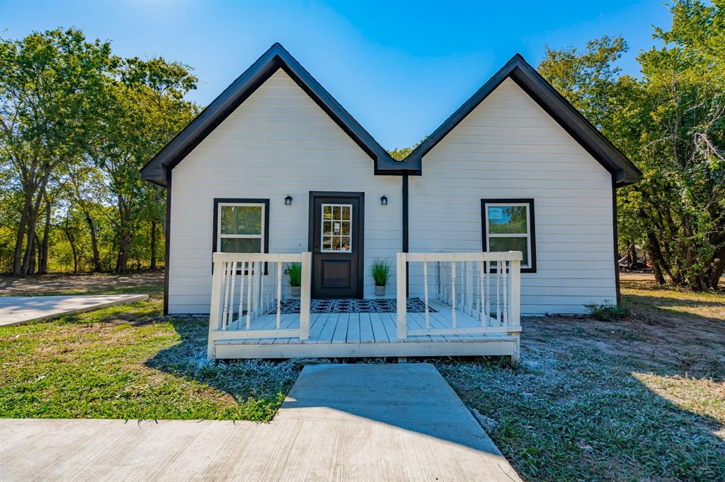 a view of a house with wooden fence next to a yard