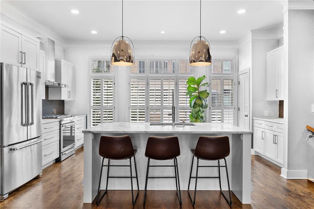 a kitchen with stainless steel appliances a table and chairs in it