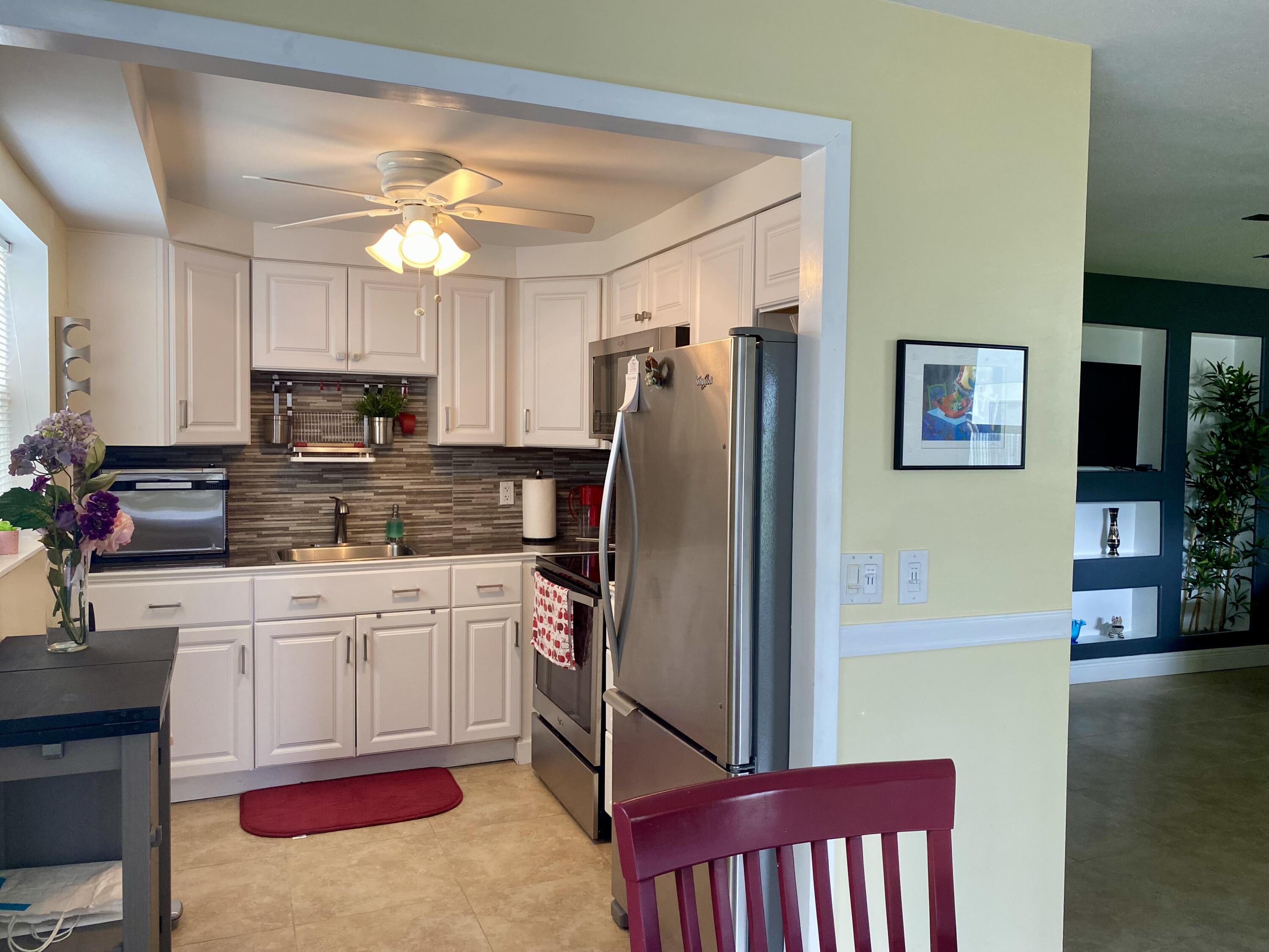 a kitchen with stainless steel appliances granite countertop a refrigerator stove top oven a sink and dishwasher