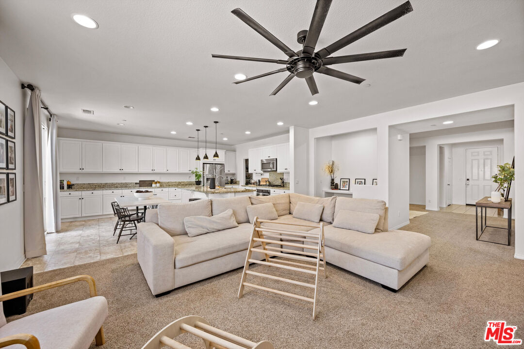 a living room with furniture and a view of kitchen