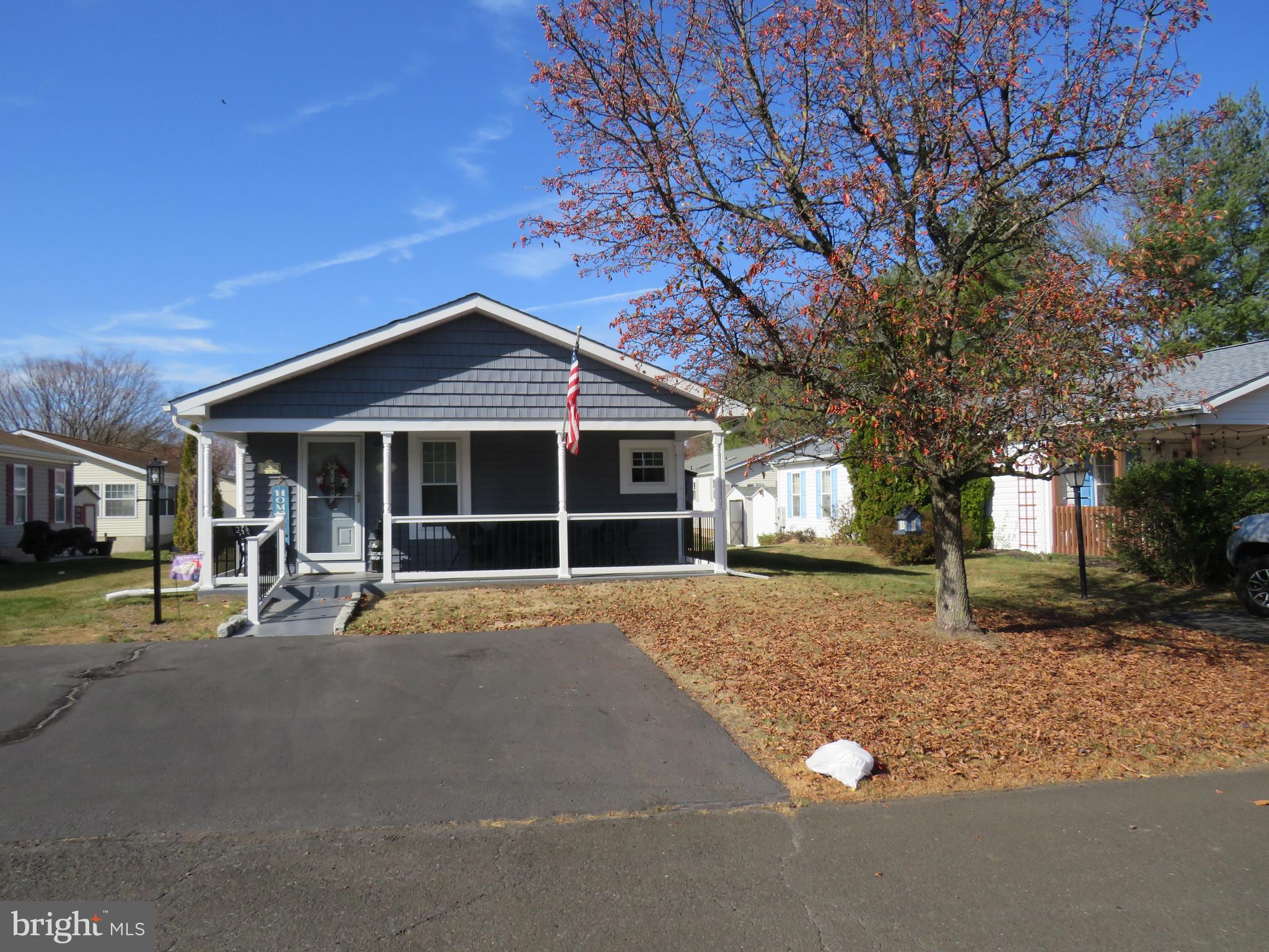 a front view of a house with a garden and trees