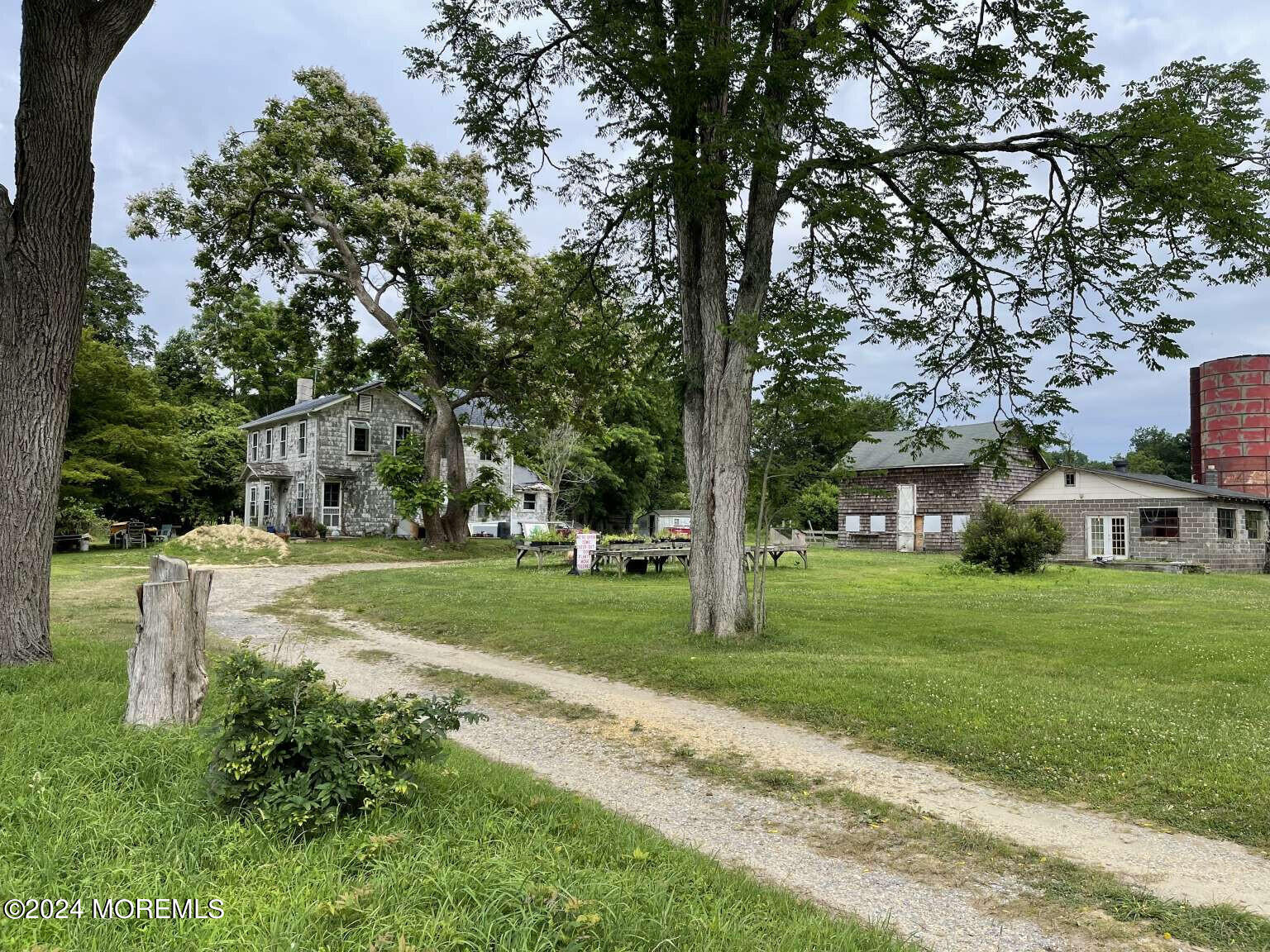 a view of a big house with a big yard and large trees