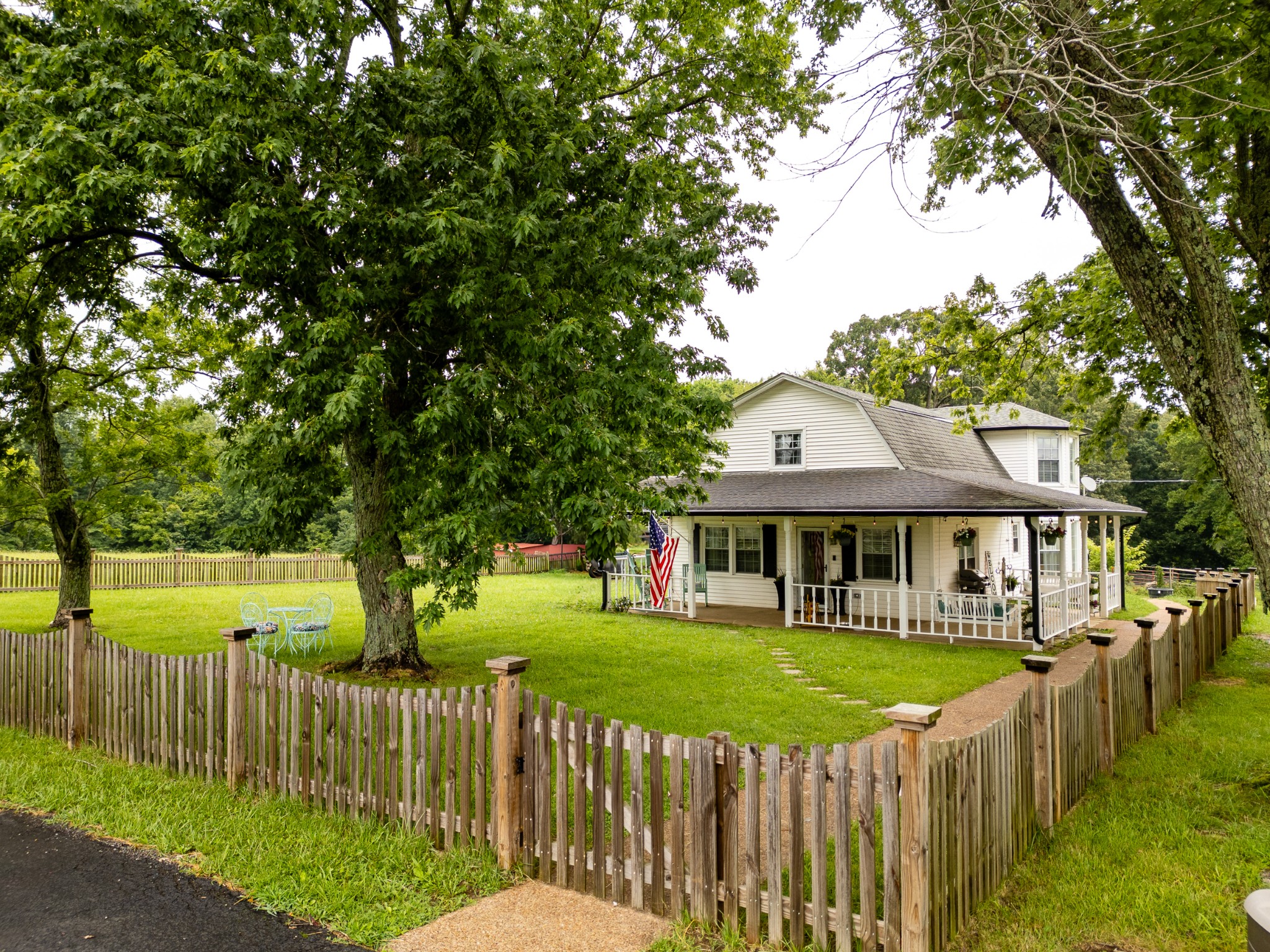 a view of an house with backyard and a tree