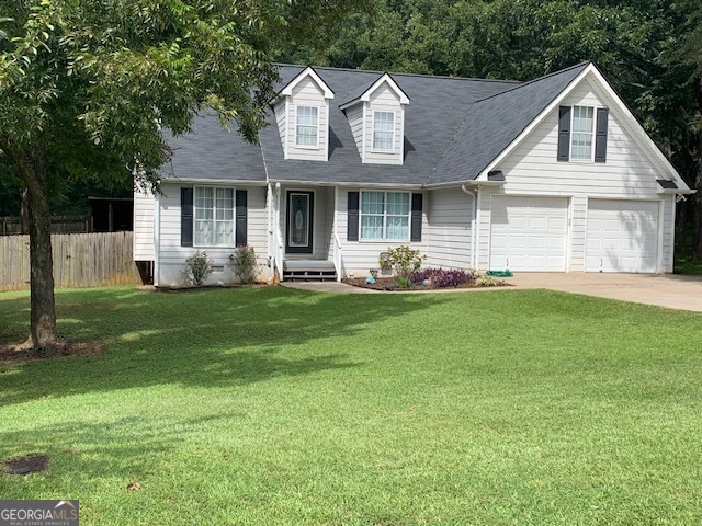 a front view of a house with yard and green space