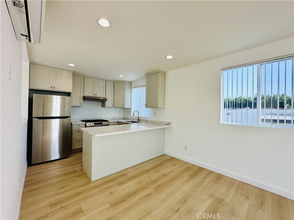 a kitchen with a refrigerator and a stove top oven