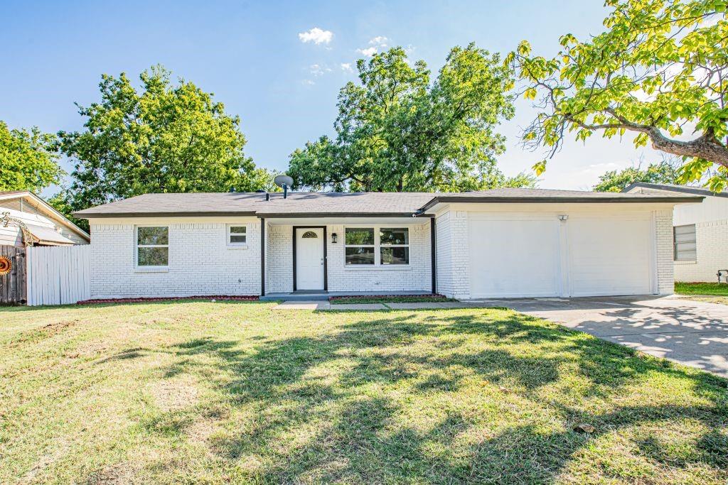 Single story home featuring a garage and a front yard