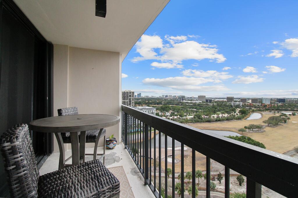 a view of a balcony with furniture and a floor to ceiling window