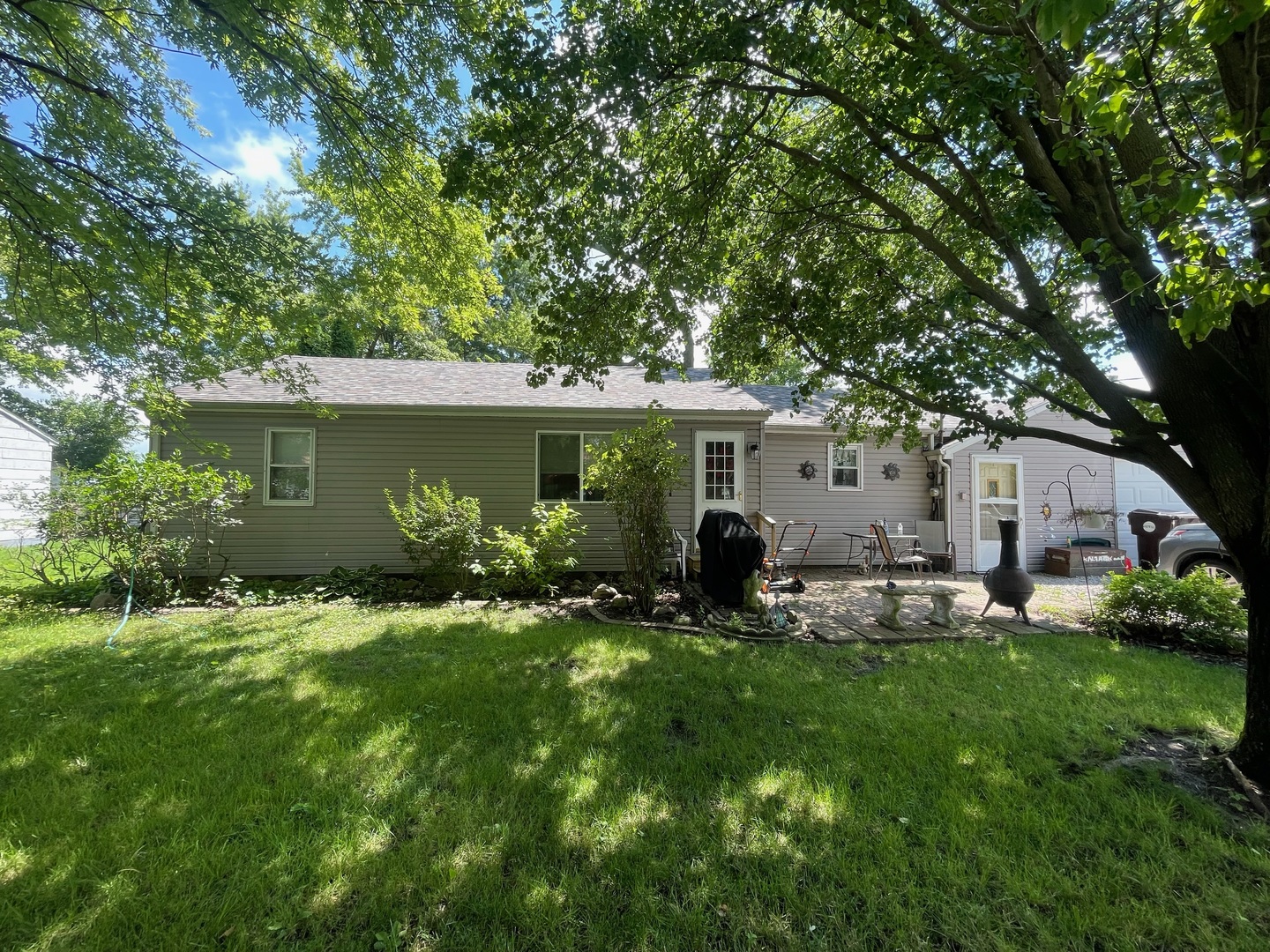 a front view of house with a garden and trees