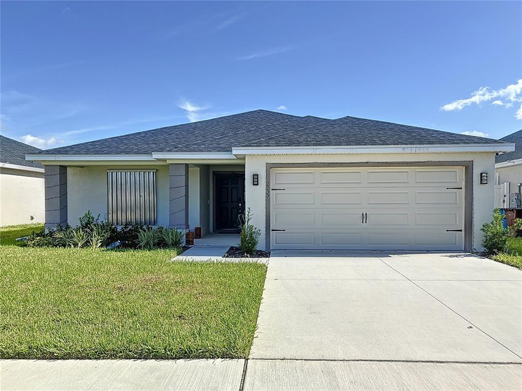 a front view of a house with a yard and garage