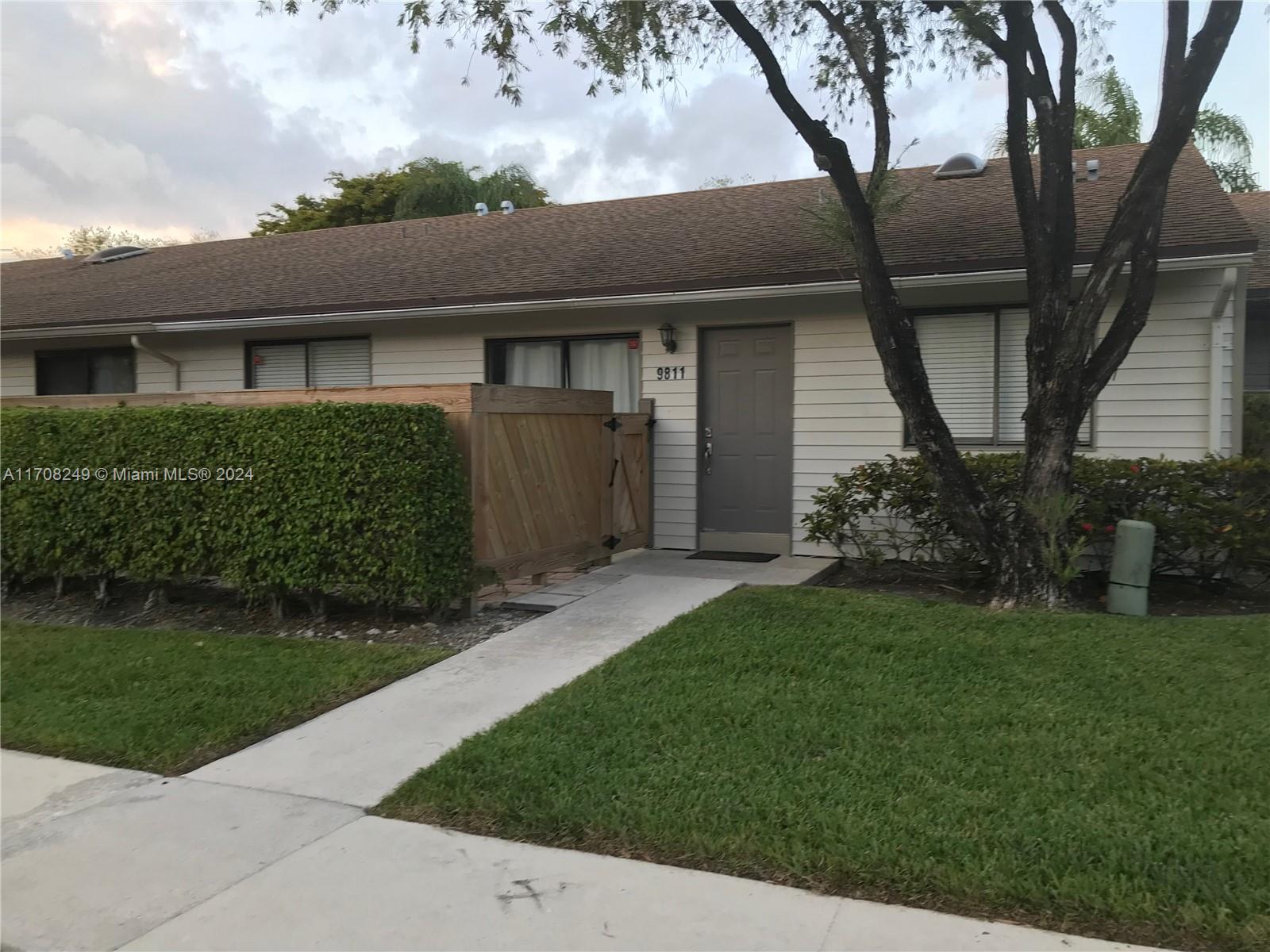 a front view of a house with a garden and yard