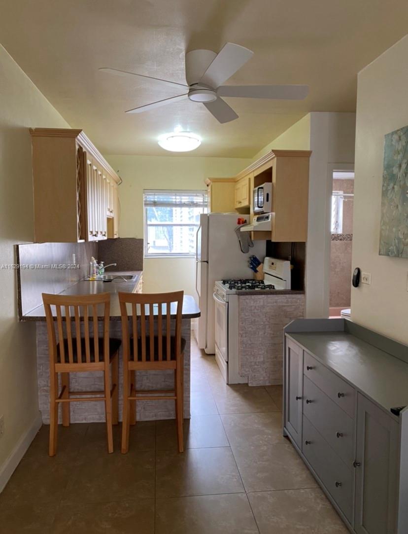 a kitchen that has a lot of cabinets a sink and a stove in it