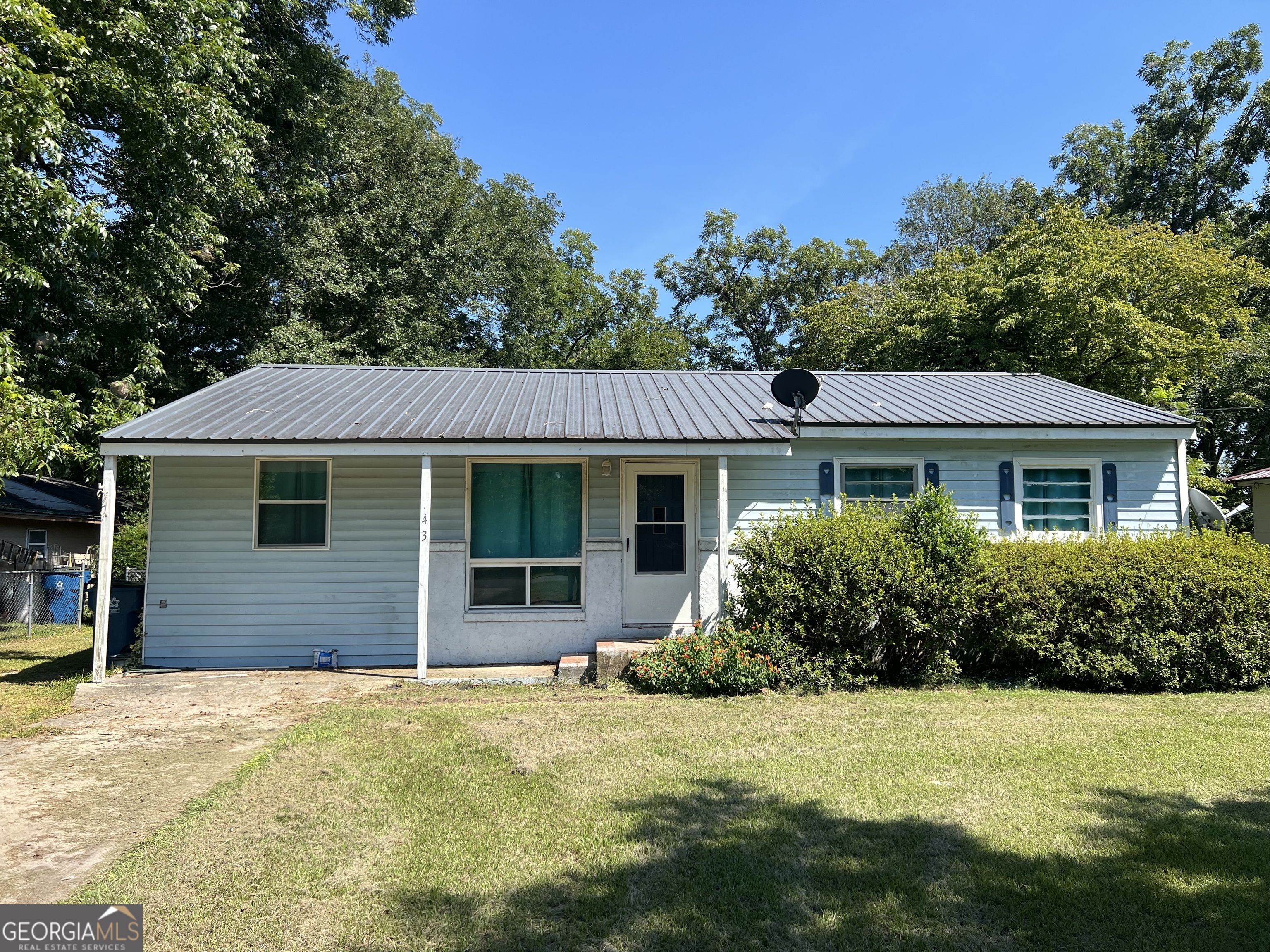 a front view of house with yard and trees around