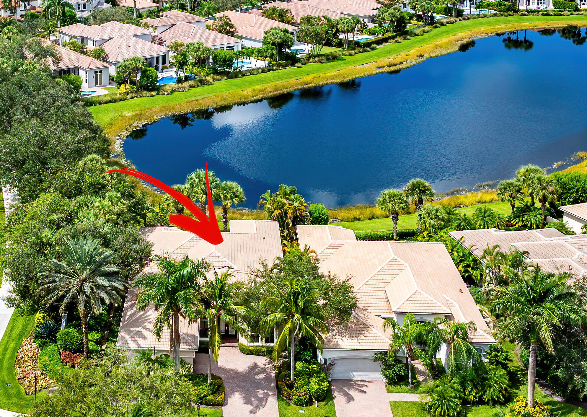 an aerial view of a house with a yard and lake view