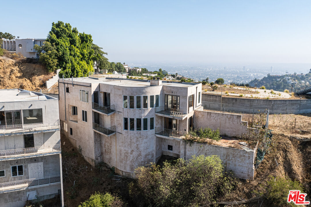 an aerial view of residential houses with outdoor space and trees