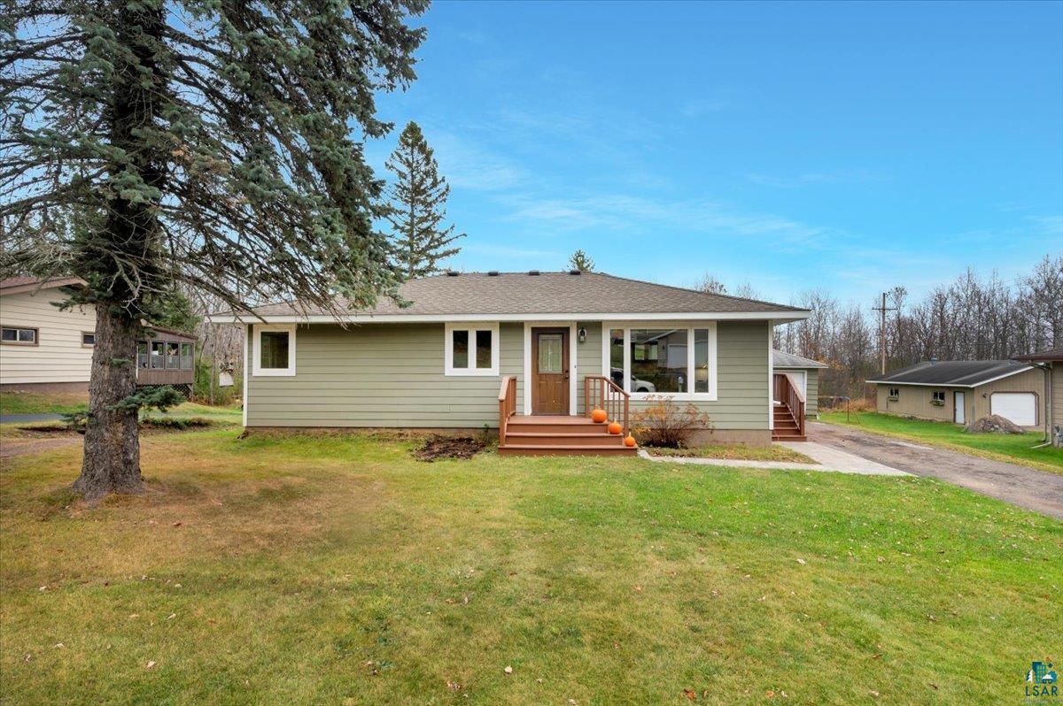 Ranch-style home featuring a garage and a front lawn