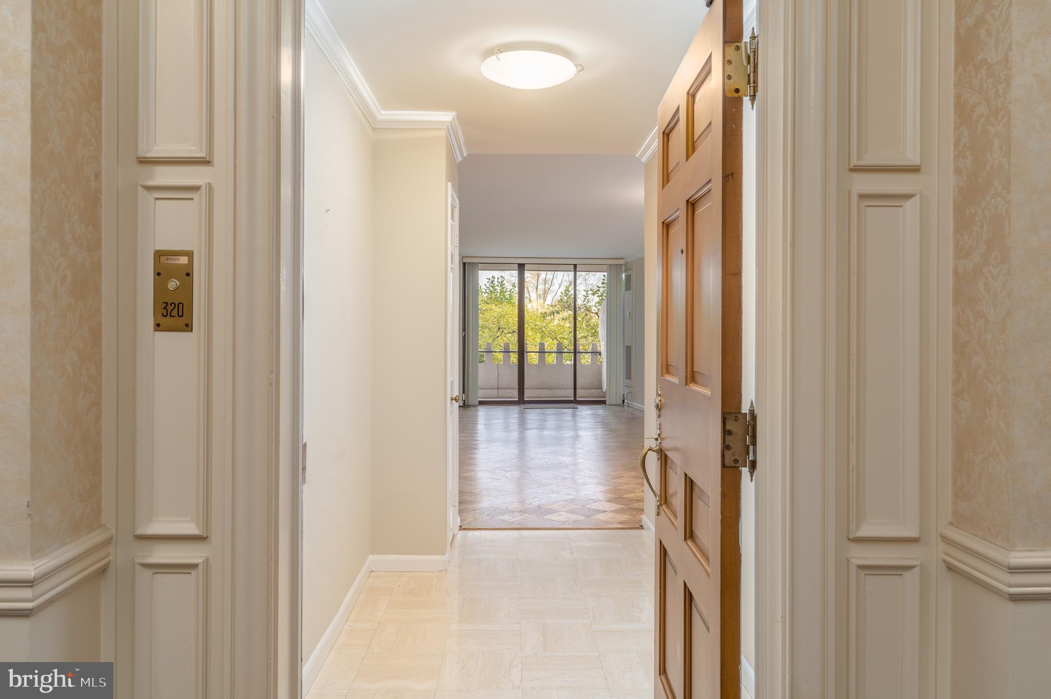 a view of a hallway with wooden floor and door