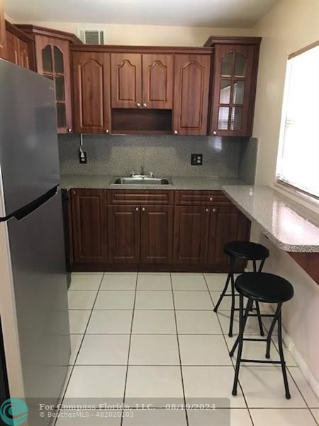 a kitchen with a sink a stove cabinets and a window