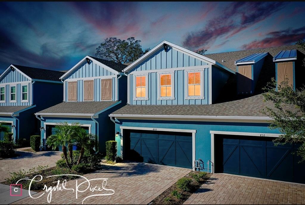 a front view of a house with yard and parking