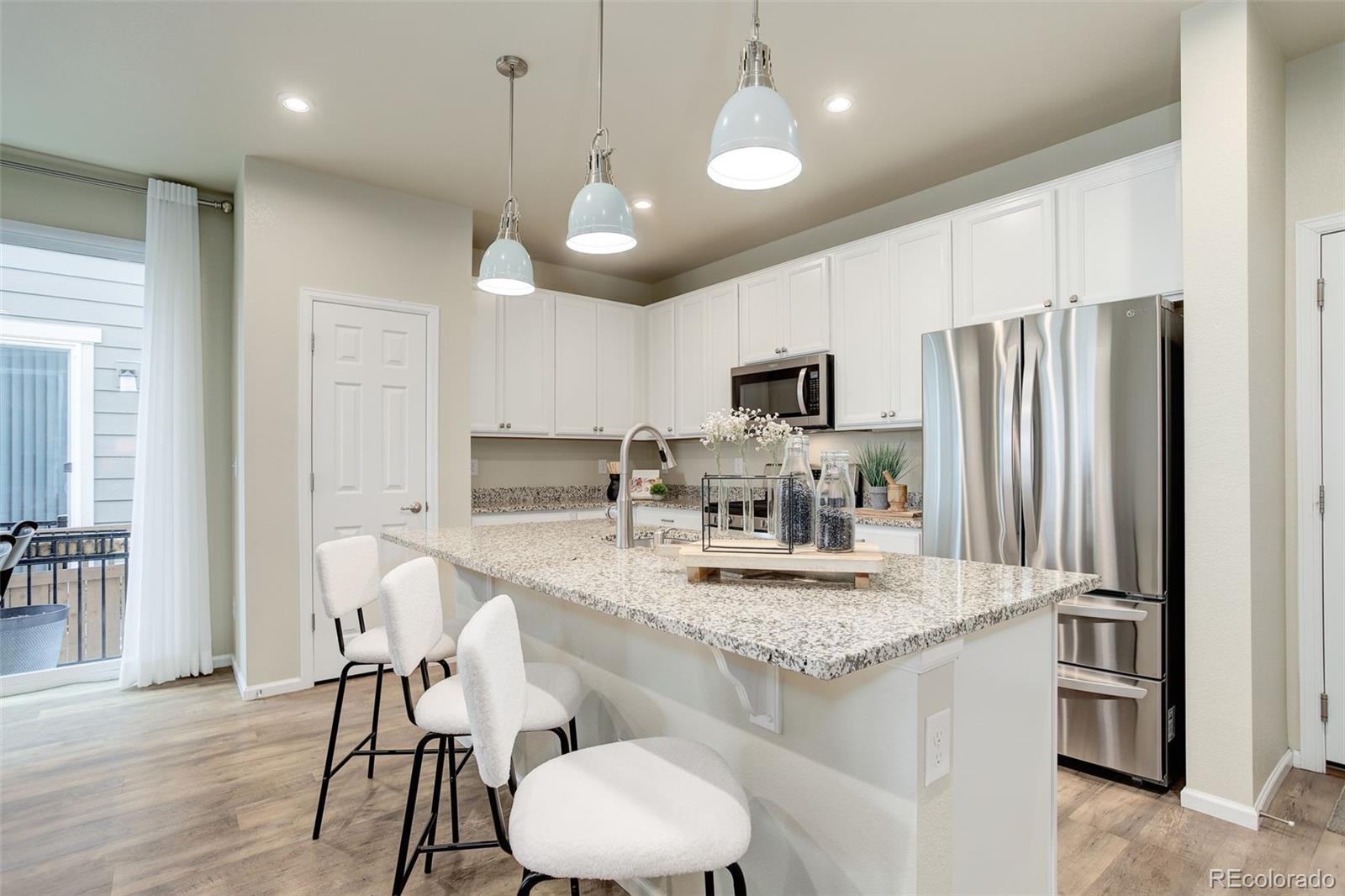 a kitchen with stainless steel appliances granite countertop a sink refrigerator and cabinets