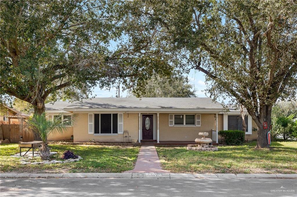 a front view of a house with yard porch and tree