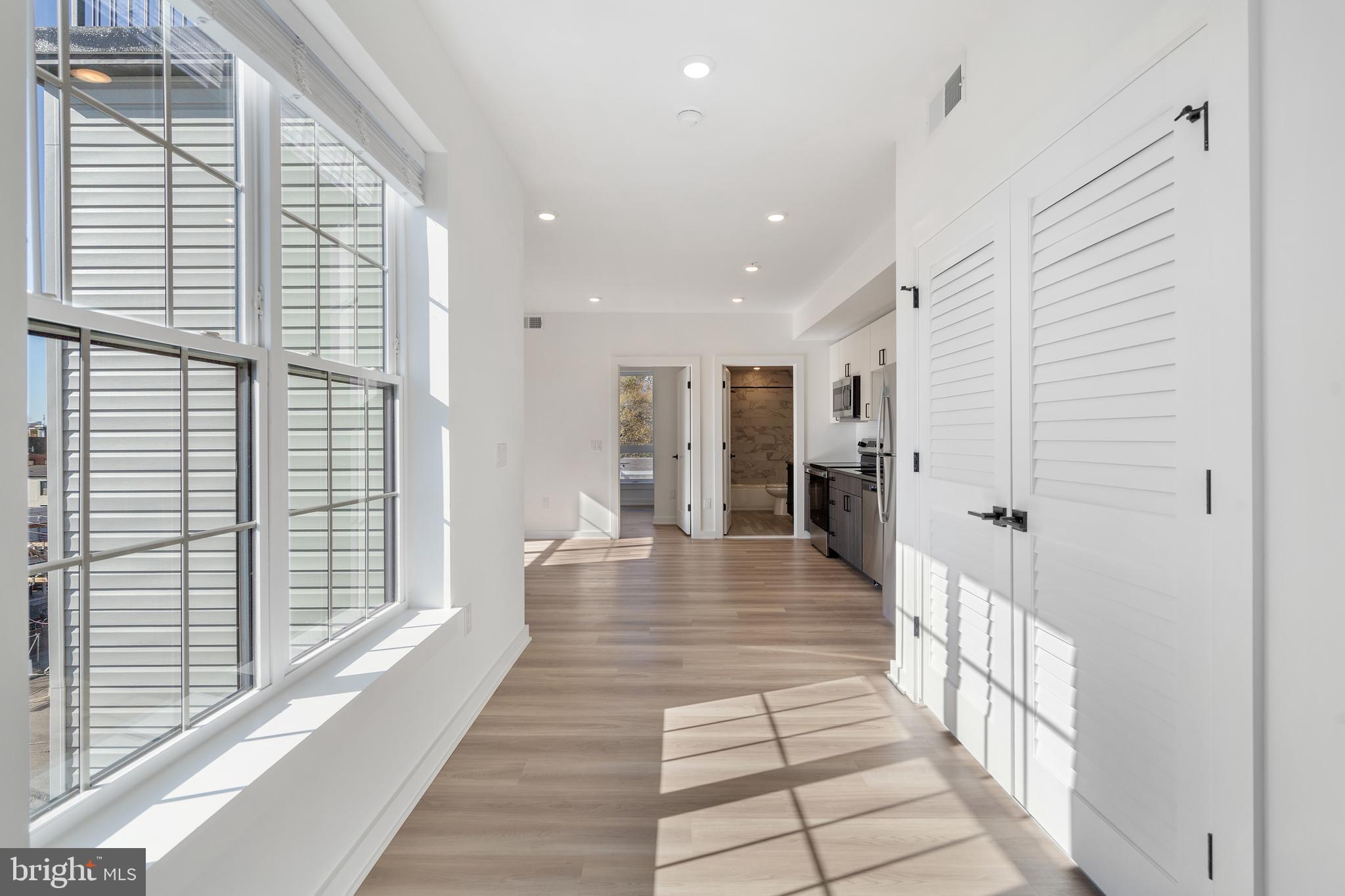 a view of a hallway with wooden floor and staircase