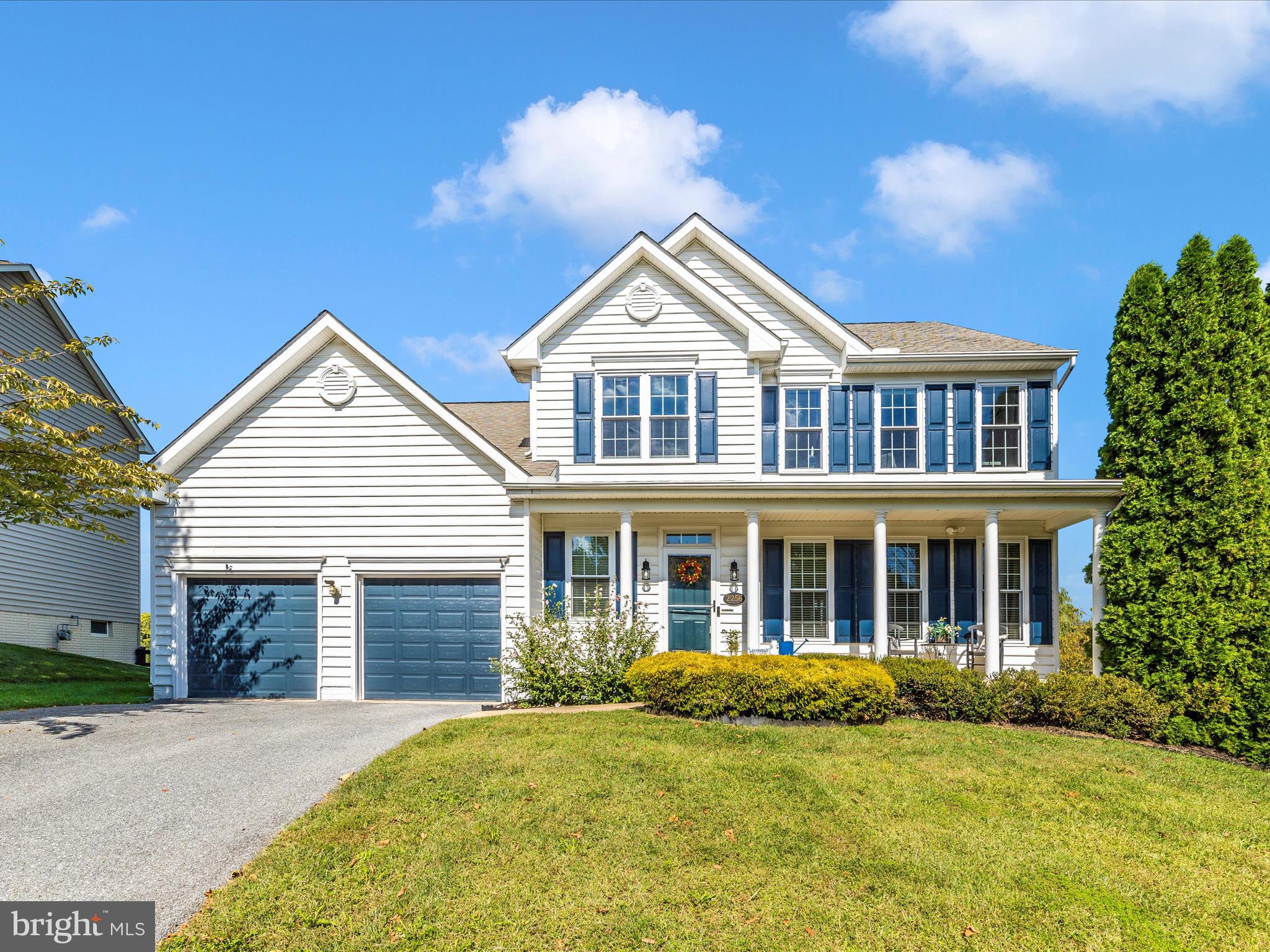 a front view of a house with yard and green space