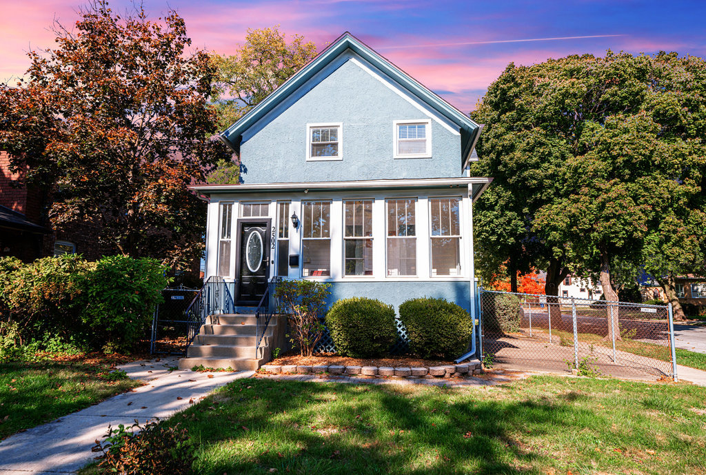 a front view of a house with a yard and potted plants