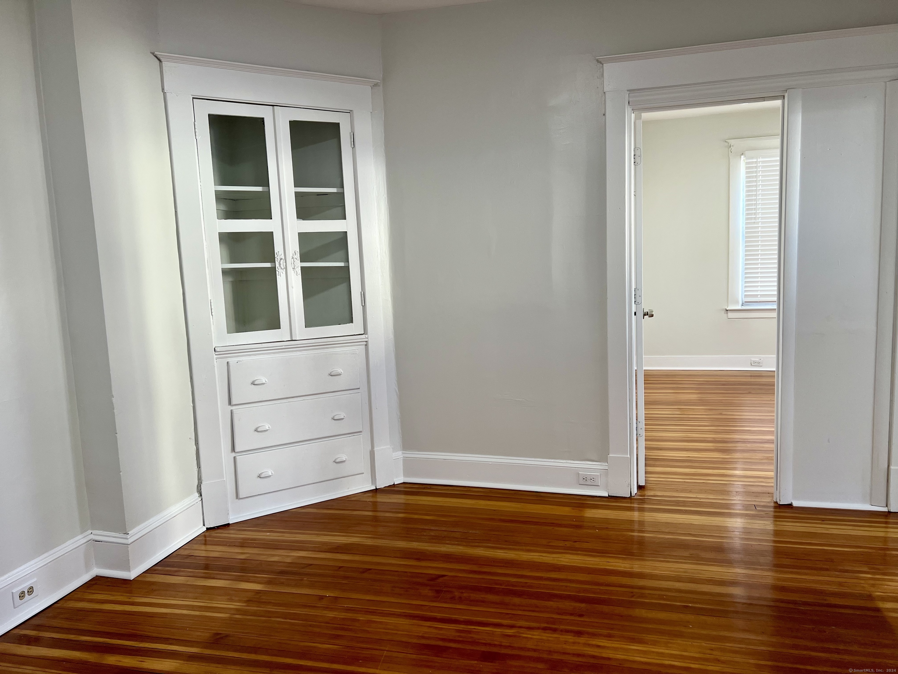 a view of a bedroom with wooden floor and closet