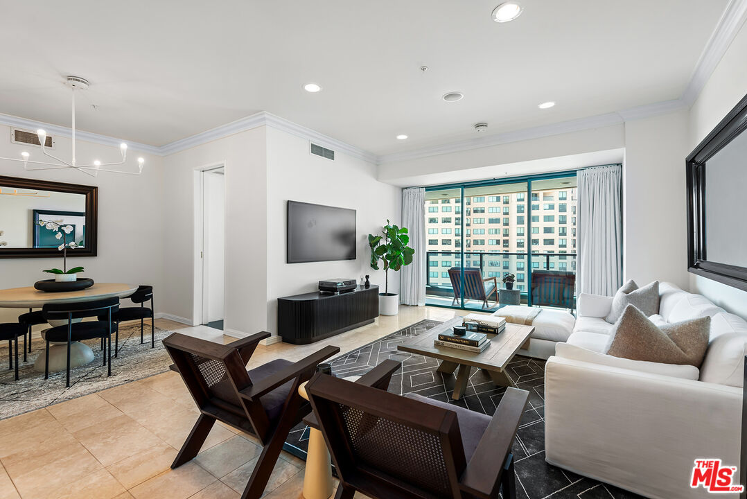 a living room with furniture a flat screen tv and a floor to ceiling window