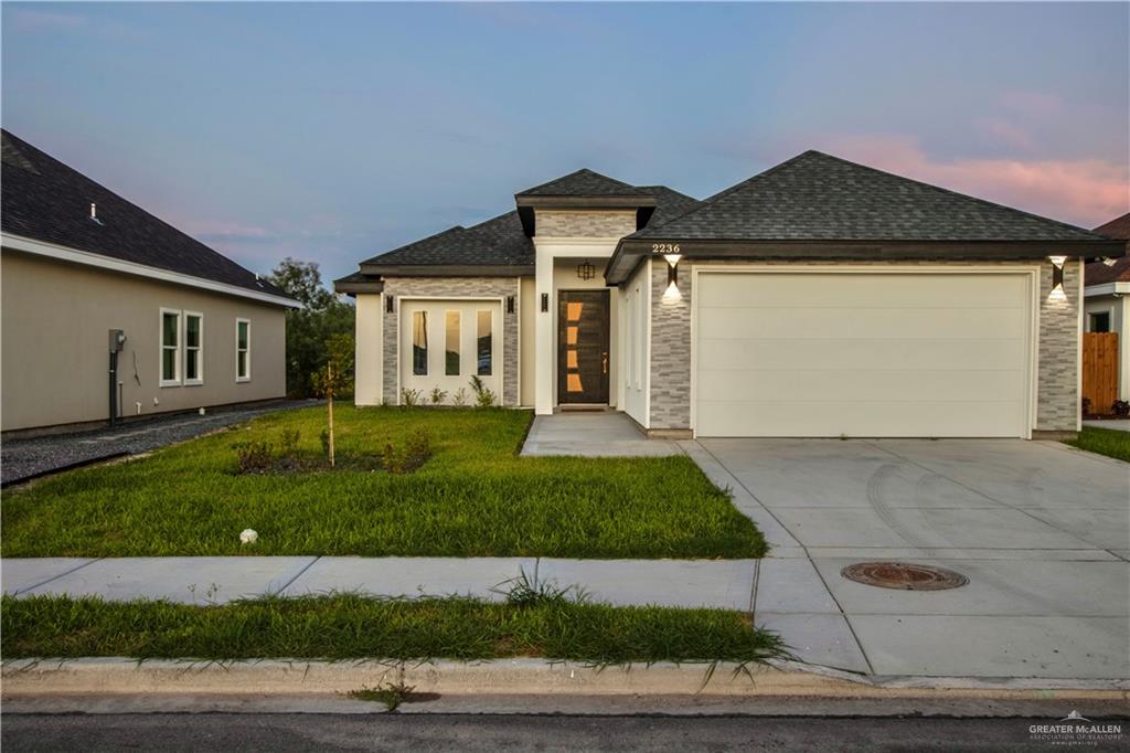 a front view of a house with a yard and garage