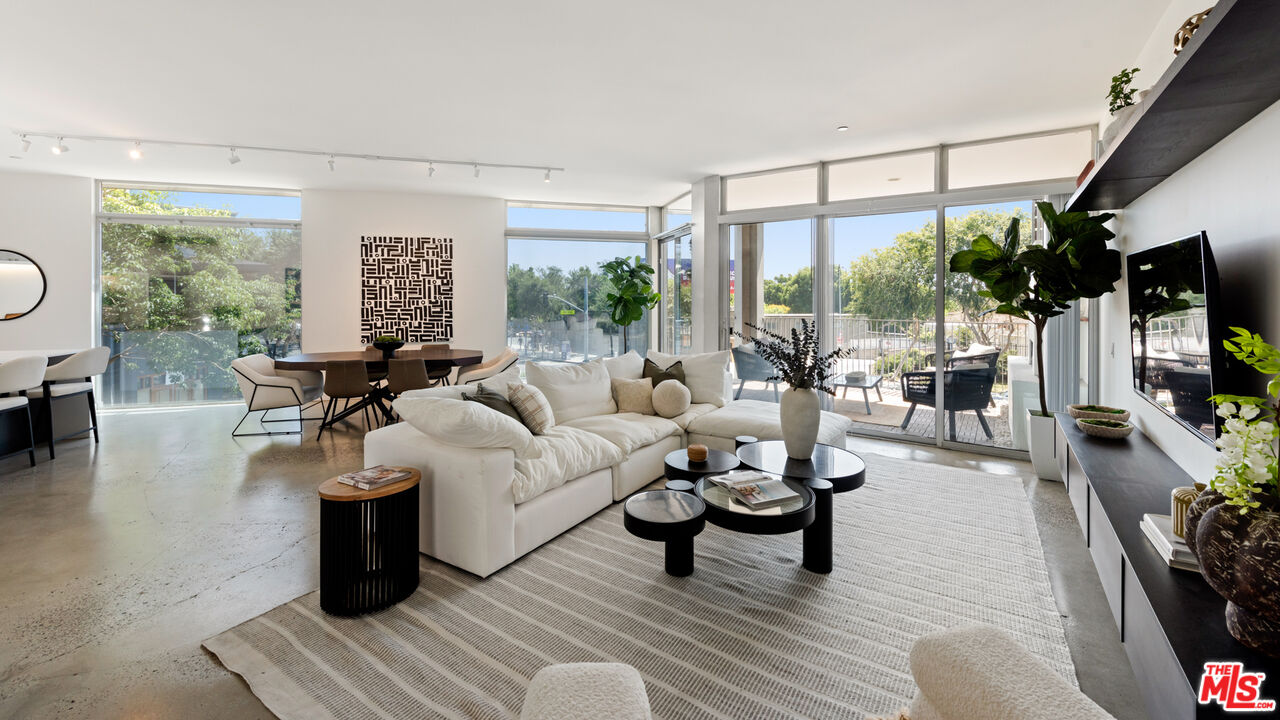 a living room with furniture a flat screen tv and a large window