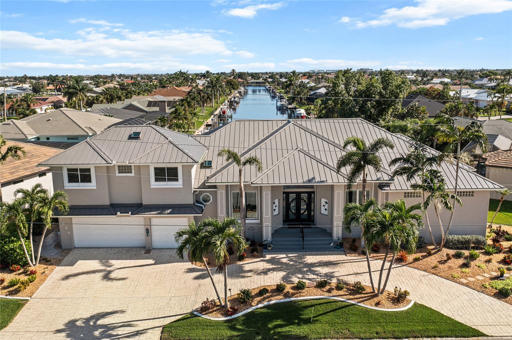 a aerial view of a house with garden and tall trees