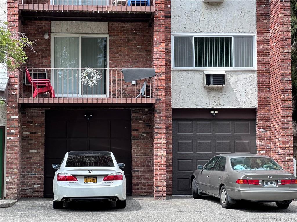 View of front of home featuring a balcony and a garage