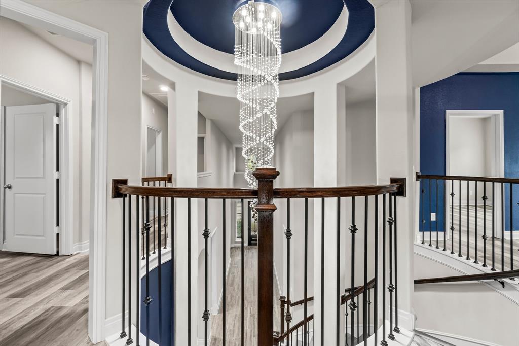 a view of a hallway with a chandelier and wooden floor